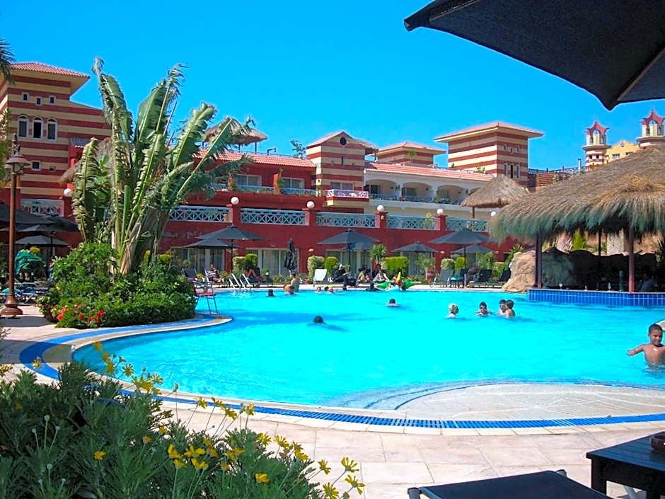 Resort swimming pool with swimmers and terracotta buildings - chalet in Porto Marina, North Coast