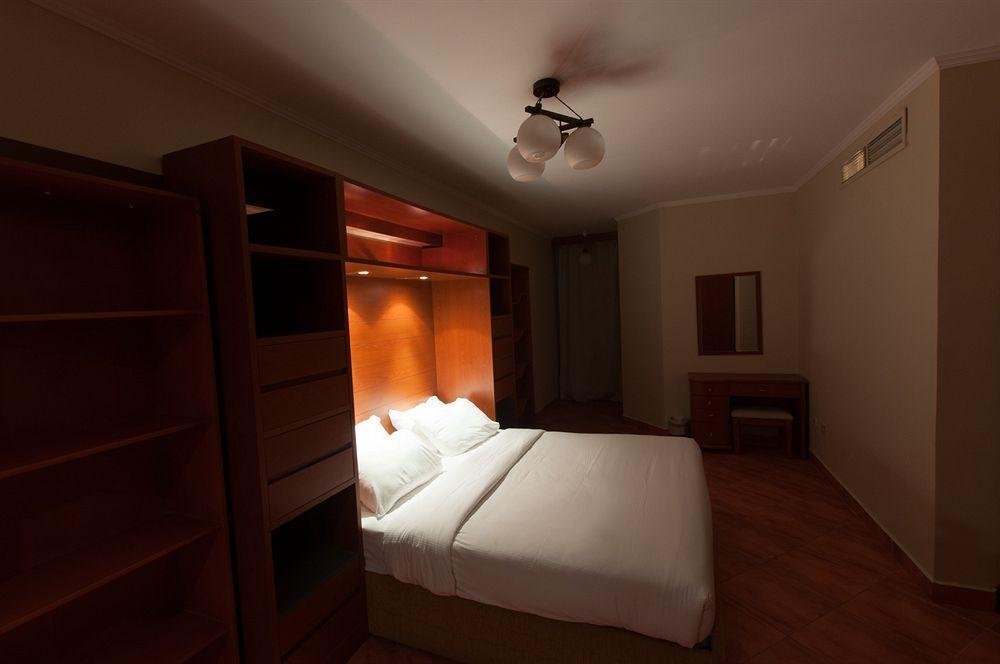 Bedroom with wooden wardrobe and a double bed - chalet in Porto Marina, North Coast