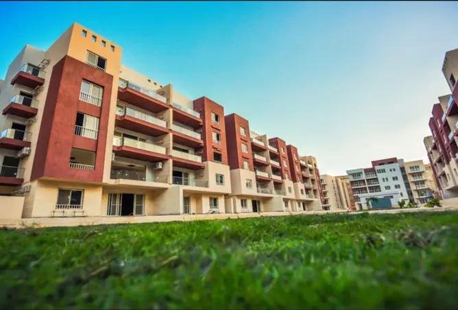 بلوكات سكنية ببلكونات حمراء وكريمي خلف نجيل - شقة في بروميناد وادي دجلة، التجمع الخامس