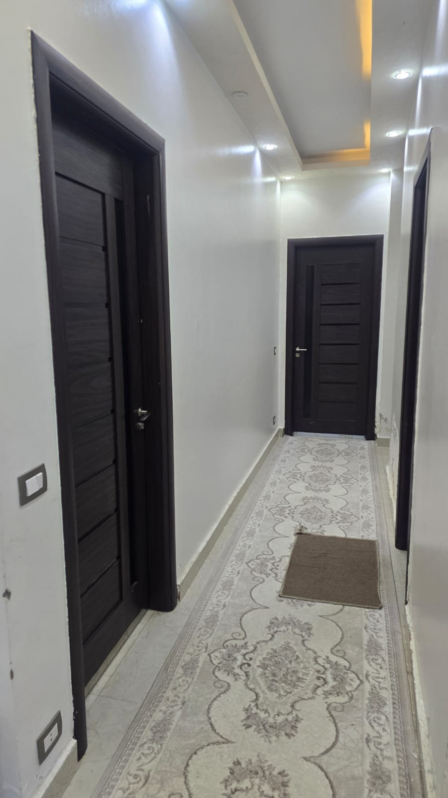 Entrance hallway with a dark door and a patterned floor - unit in Al Banafseg 4, New Cairo