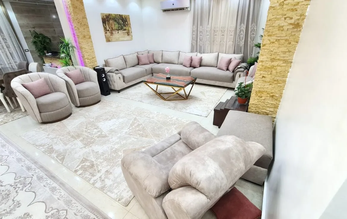 Living room with pink armchairs and a cream corner sofa - unit in Al Banafseg 4, New Cairo