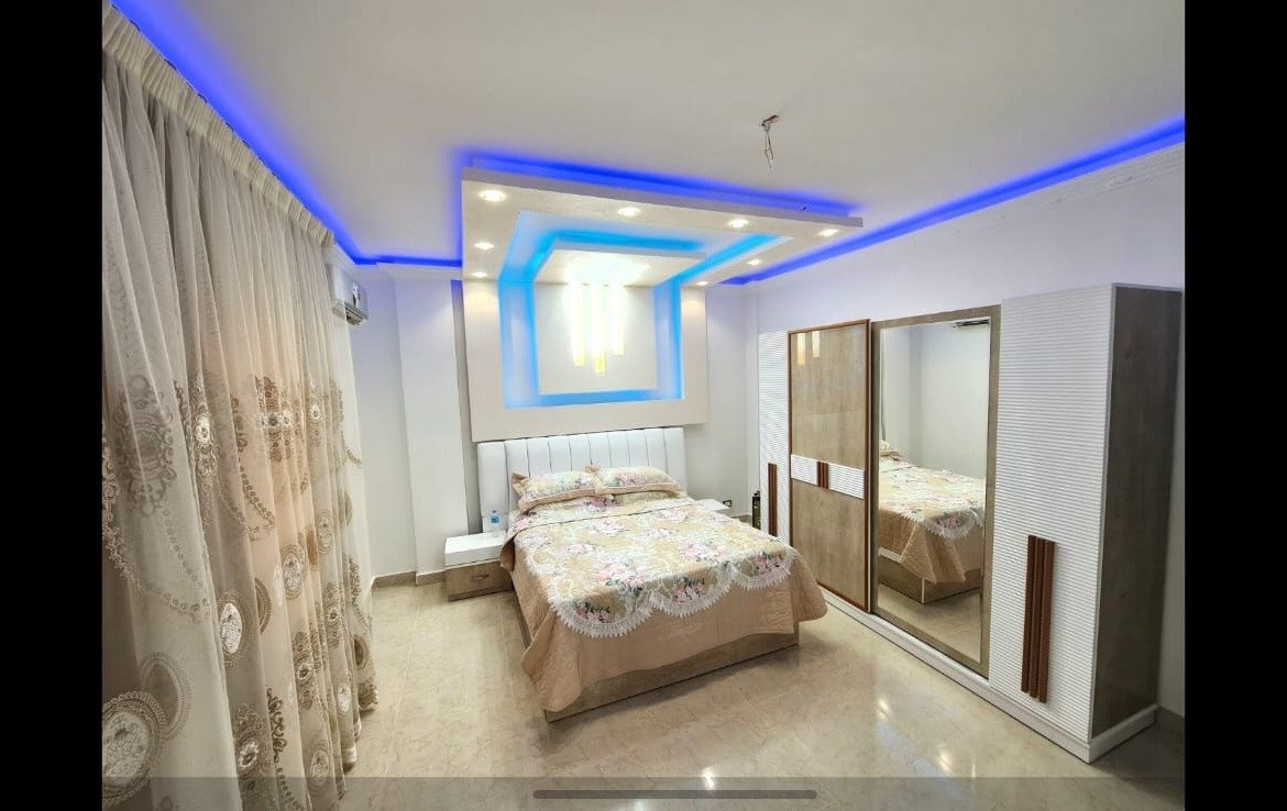 Bedroom with blue ceiling lights and a mirrored wardrobe - unit in Al Banafseg 4, New Cairo