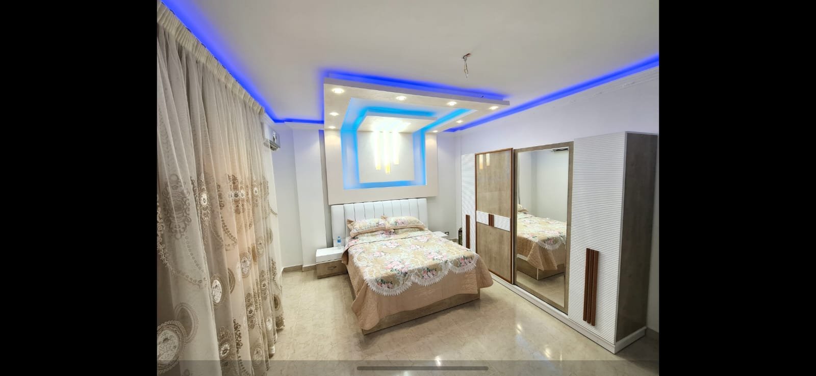 Bedroom with blue ceiling lights and a mirrored wardrobe - unit in Al Banafseg 4, New Cairo