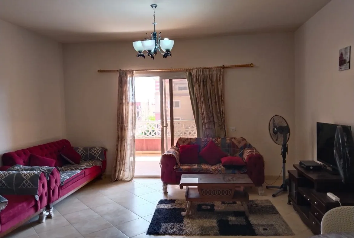 Living room with pink sofas and a balcony door - chalet in Rozana, North Coast