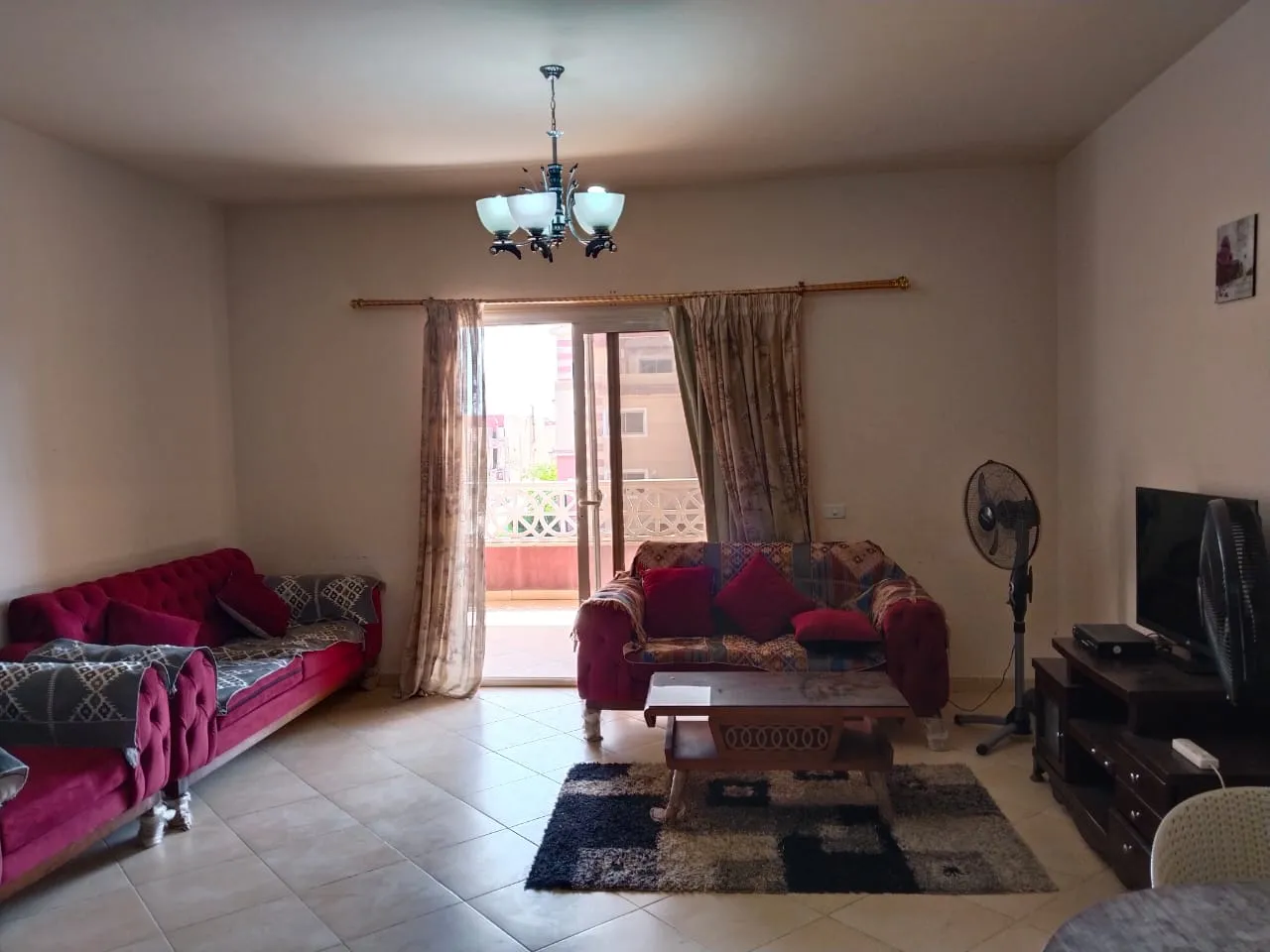 Living room with pink sofas and a balcony door - chalet in Rozana, North Coast