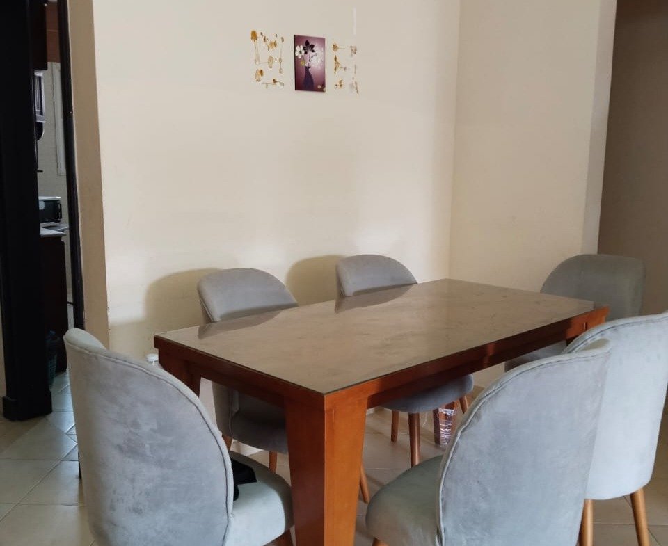 Dining table with grey chairs beside a doorway - chalet in Rozana, North Coast