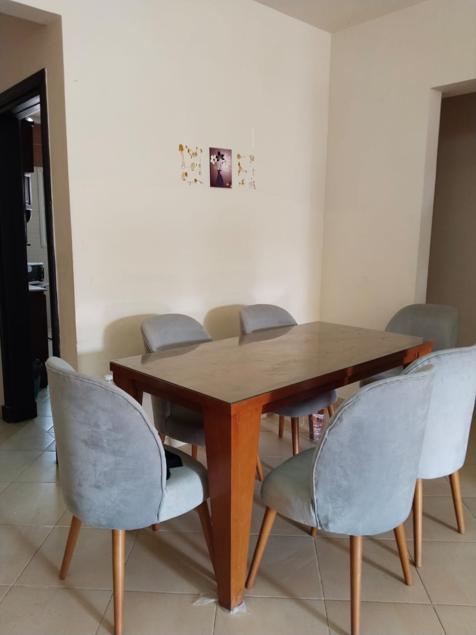 Dining table with grey chairs beside a doorway - chalet in Rozana, North Coast