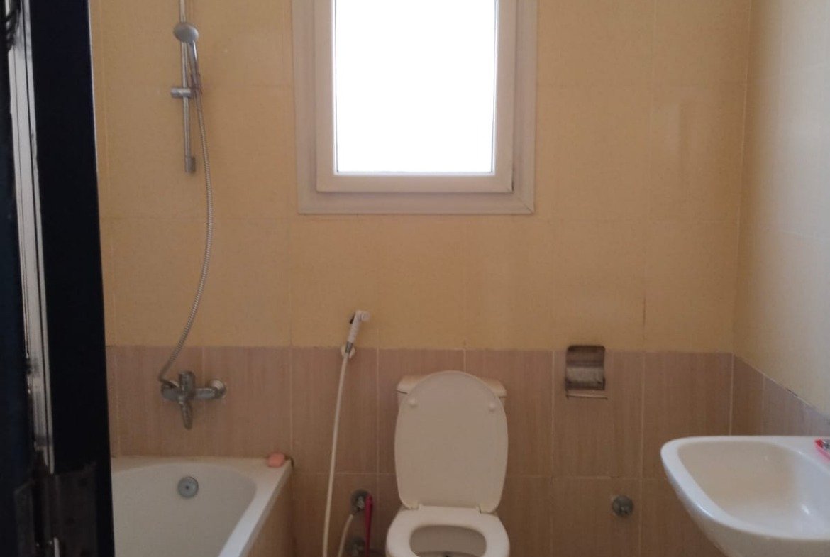 Bathroom with bathtub, toilet and small window - chalet in Rozana, North Coast