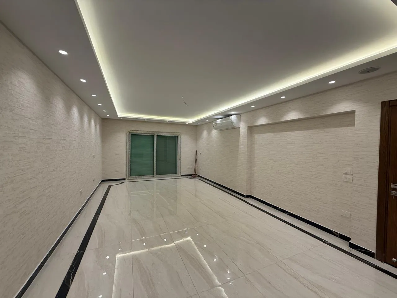 Long reception with a lit ceiling edge and glossy marble floor - apartment in Sakan Compound, New Cairo