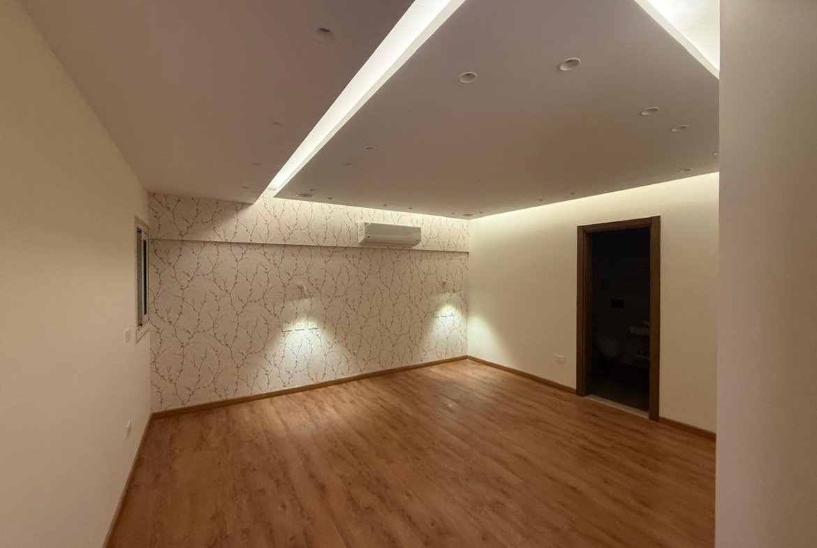 Room with parquet floor and a ceiling light line - apartment in Sakan Compound, New Cairo