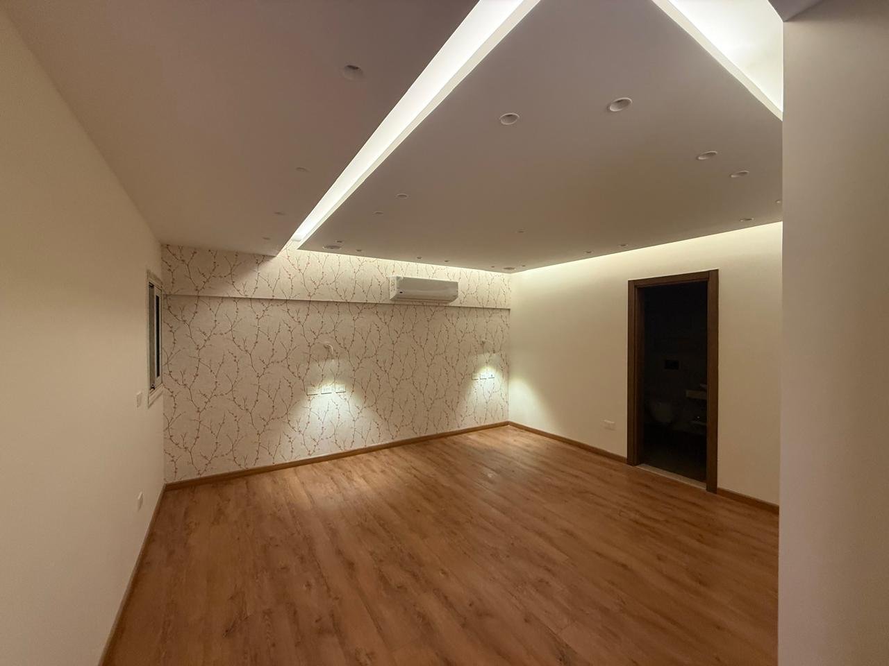 Room with parquet floor and a ceiling light line - apartment in Sakan Compound, New Cairo