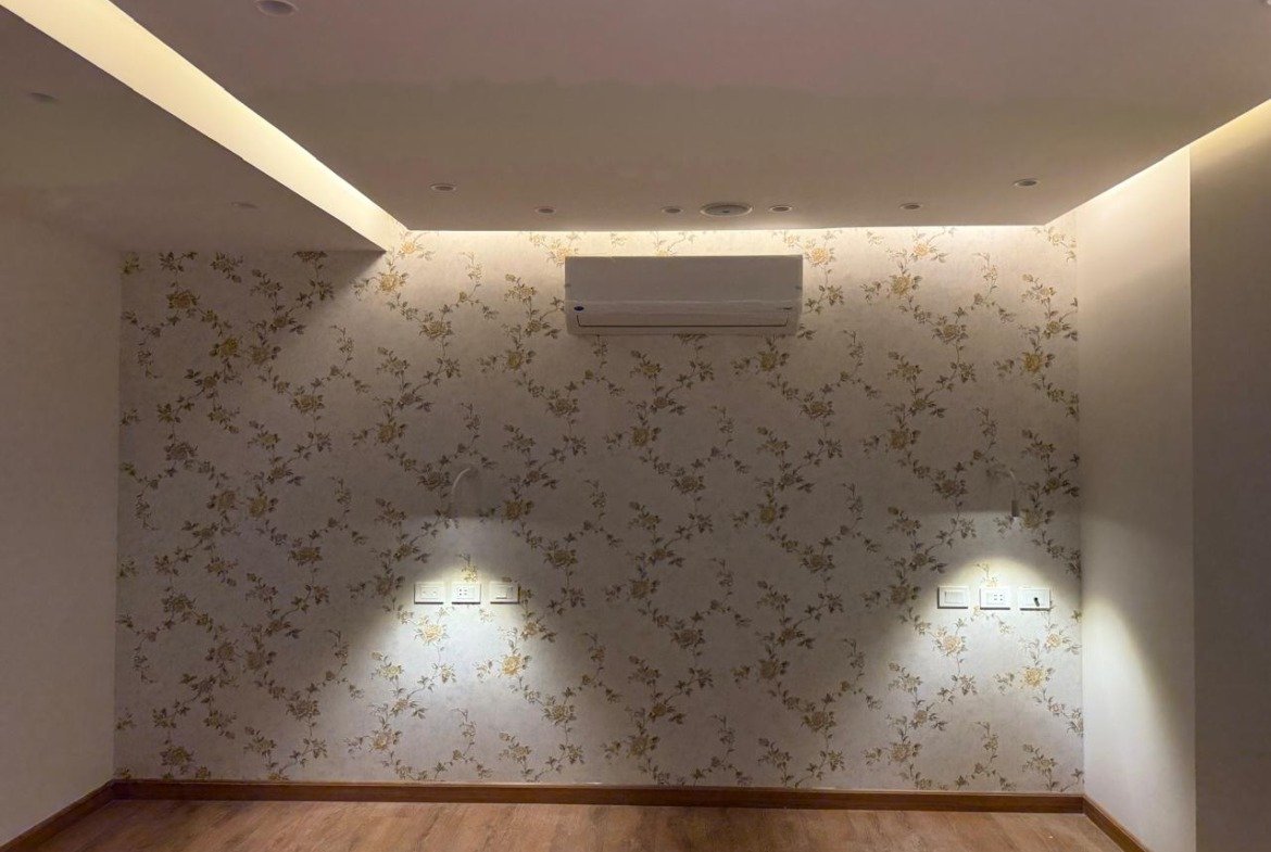 Wall with patterned wallpaper and two wall lights - apartment in Sakan Compound, New Cairo