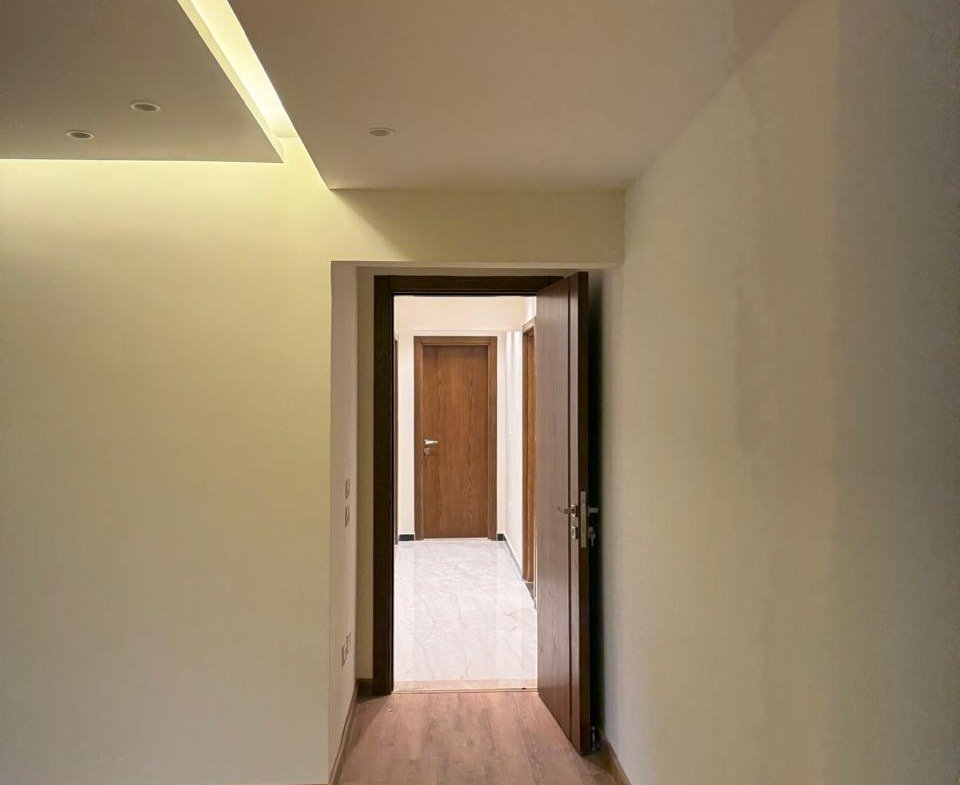 Parquet hallway opening onto another room - apartment in Sakan Compound, New Cairo