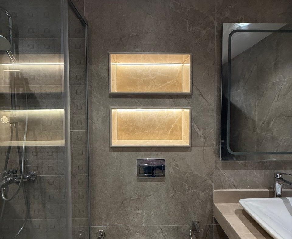 Toilet and basin beside lit wall niches - apartment in Sakan Compound, New Cairo