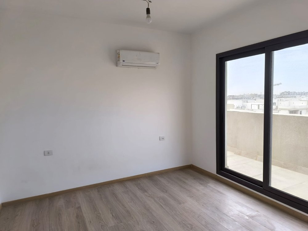 Empty bedroom with balcony door and air conditioner - sky loft in Fifth Square, New Cairo