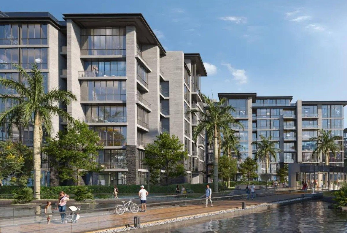 Apartment buildings along a water channel with a promenade - apartment in The View by Waterway, New Cairo