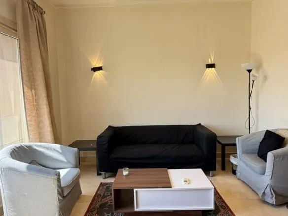 Furnished living room in 1 bedroom apartment for sale in The Village Palm Hills New Cairo