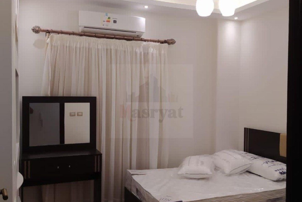 Bedroom with a wall air conditioner and sheer curtains - apartment in 3rd District, New Cairo