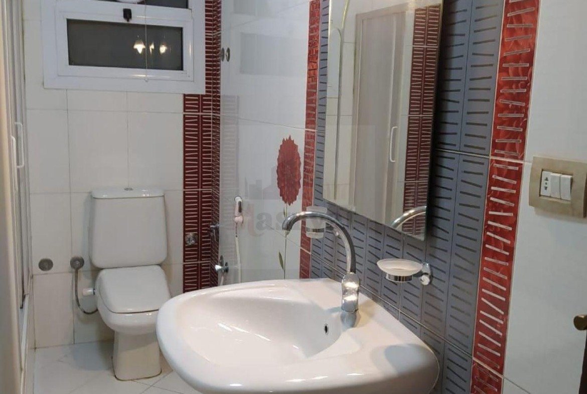 Bathroom with a round basin and red-striped tiles - apartment in 3rd District, New Cairo