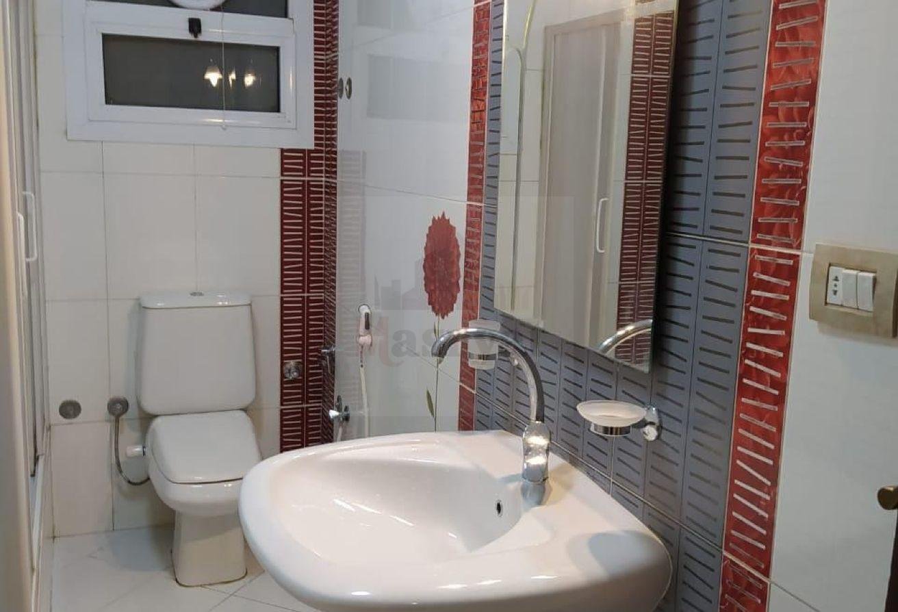 third-district-apt-135-07 Bathroom with a round basin and red-striped tiles - apartment in 3rd District, New Cairo