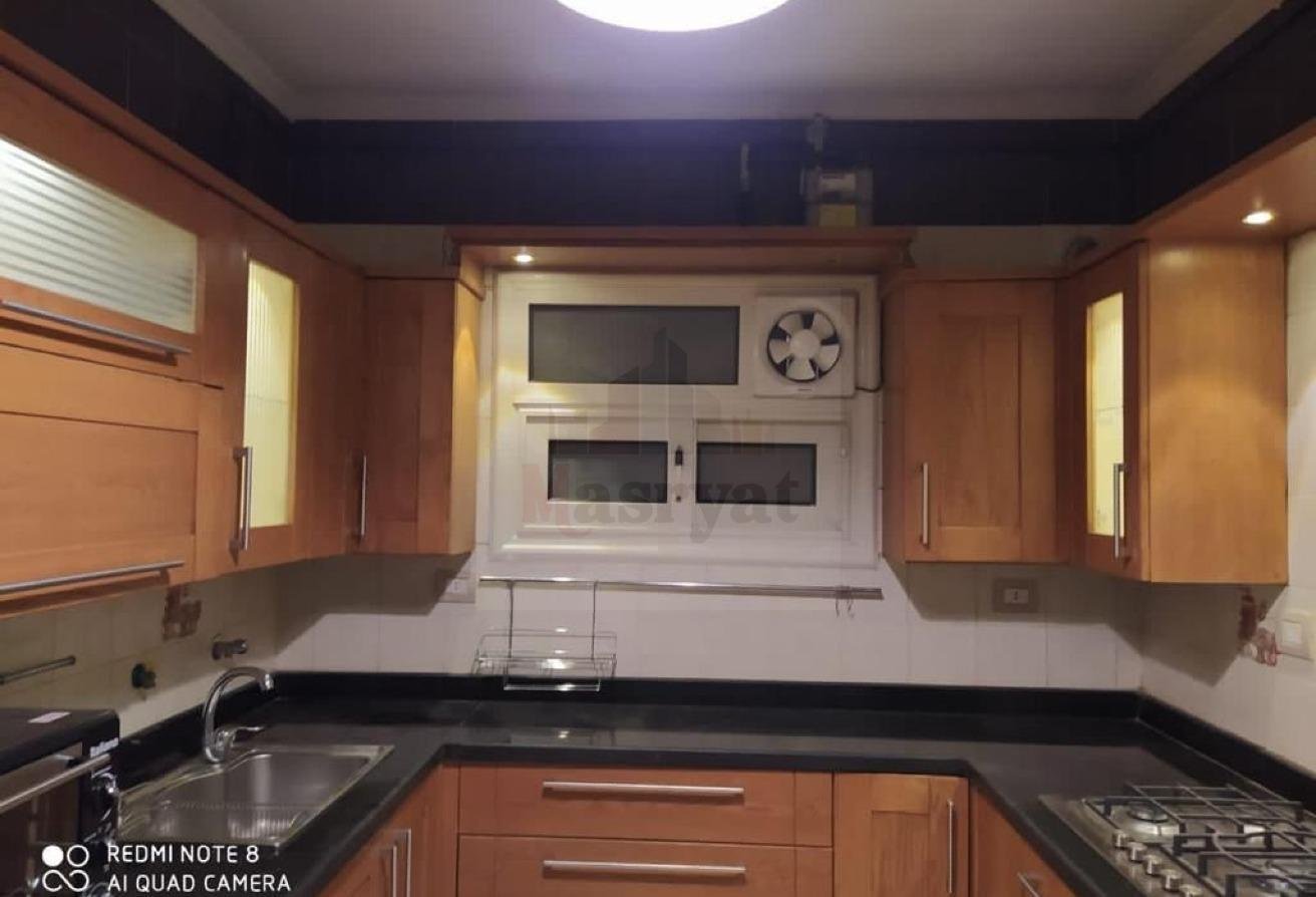 third-district-apt-135-10 Kitchen with sink, extractor fan and wood cabinets - apartment in 3rd District, New Cairo