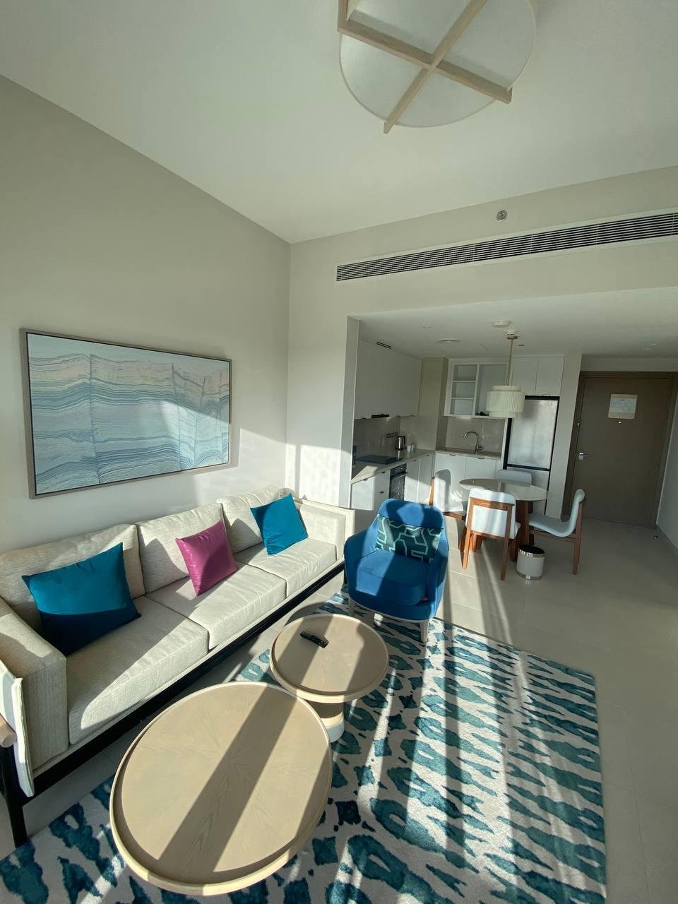 vida-marassi-WhatsApp_Image_2026-04-15_at_12.07.44_AM_2_1 غرفة معيشة بكنبة بيضاء ووسائد تركواز - شقة فندقية في فيدا مراسي، الساحل الشمالي