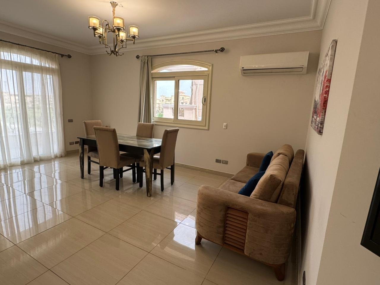 Dining table beside a sofa in a bright reception - apartment in El Yasmeen 4, New Cairo