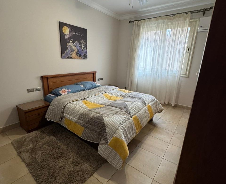 Bedroom with a yellow and grey bed cover and a ceiling fan - apartment in El Yasmeen 4, New Cairo