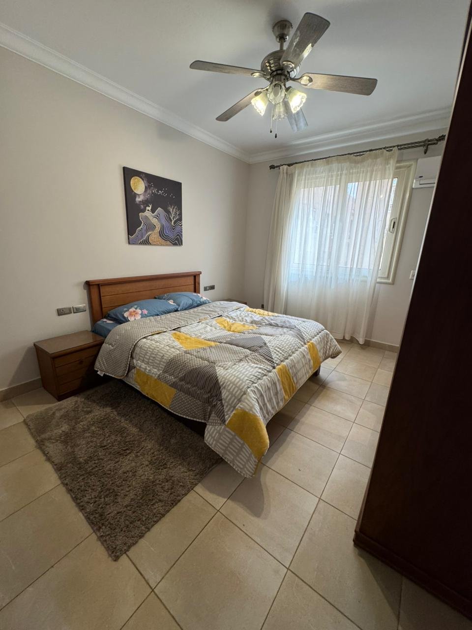 Bedroom with a yellow and grey bed cover and a ceiling fan - apartment in El Yasmeen 4, New Cairo