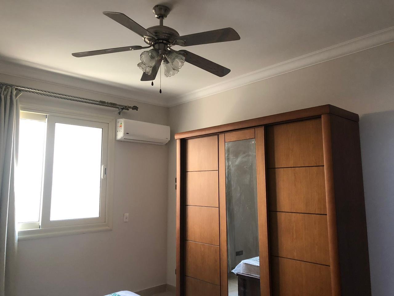 Wooden wardrobe with mirrored panel and an air conditioner - apartment in El Yasmeen 4, New Cairo